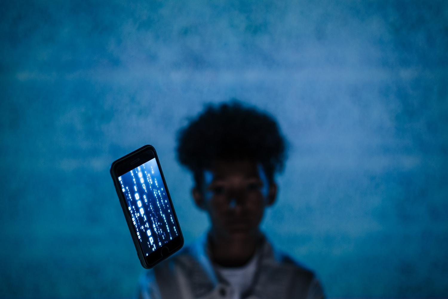 Smartphone con código binario flotando, representando la extracción de datos digitales y ciberseguridad en el análisis forense móvil.