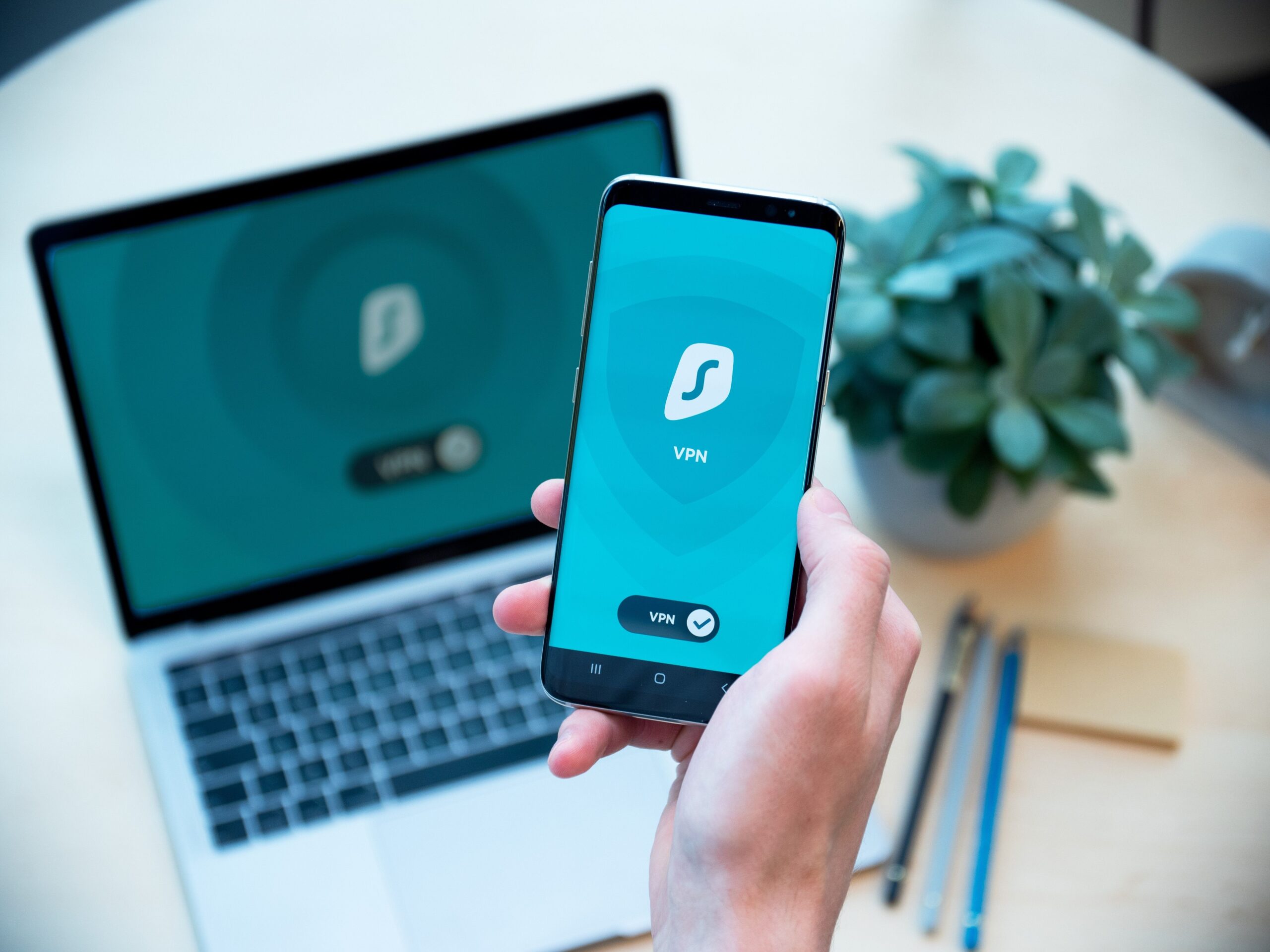 Smartphone e portátil juntos em primeiro plano, ilustrando a gestão da segurança e o controle de aplicações em diferentes dispositivos.