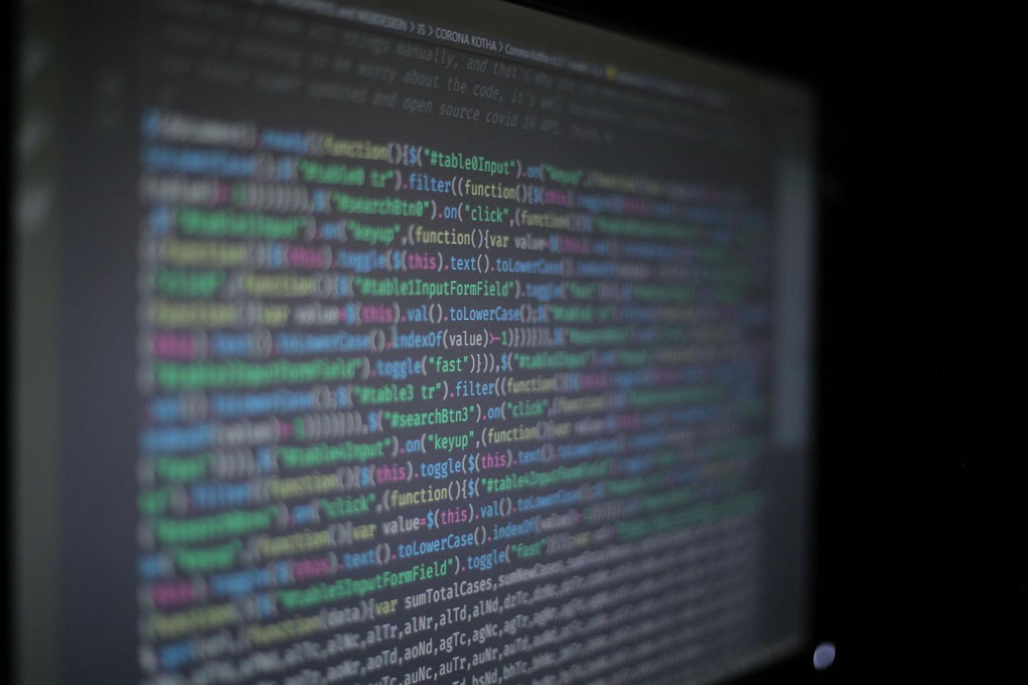 Primeiro plano artístico de código de programação em um monitor, aportando um contexto técnico e visual ao artigo.