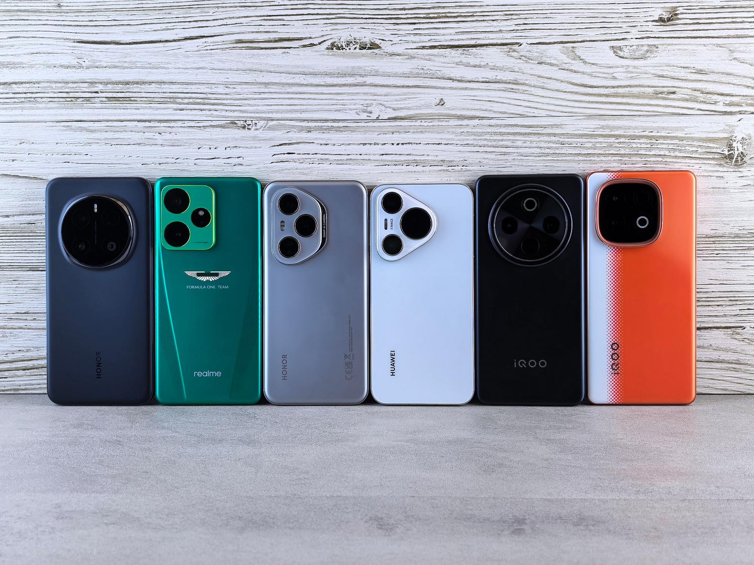 Diversos modelos de smartphones modernos sobre uma superfície de madeira, representando as distintas gamas de preço (baja, media y alta).