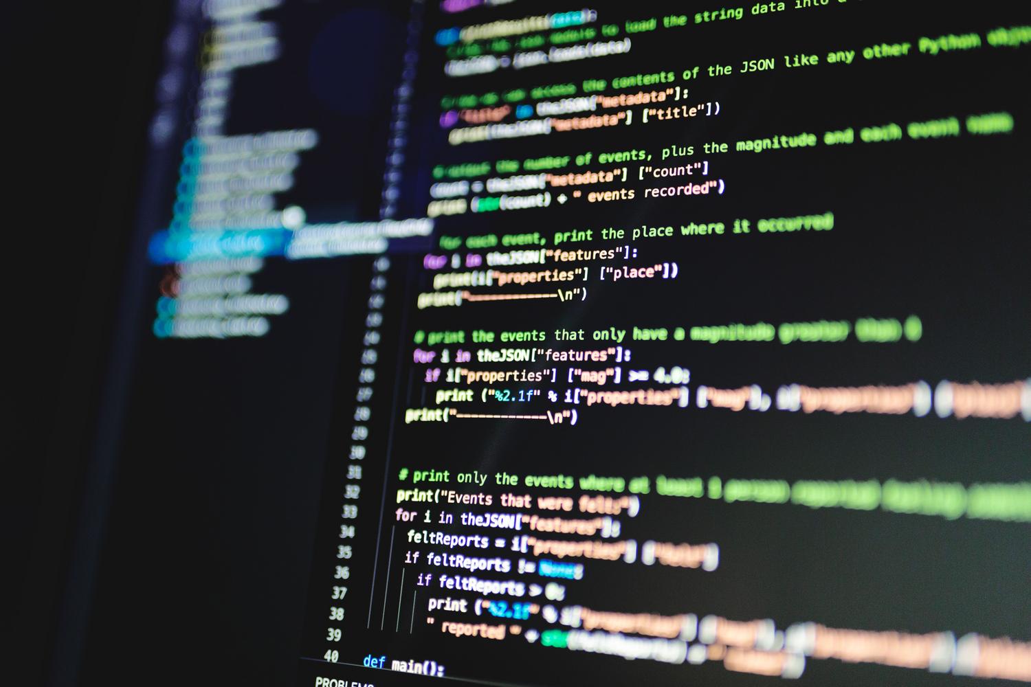 Primeiro plano de linhas de código de programación em uma tela de computador, representando o software e o código-fonte.
