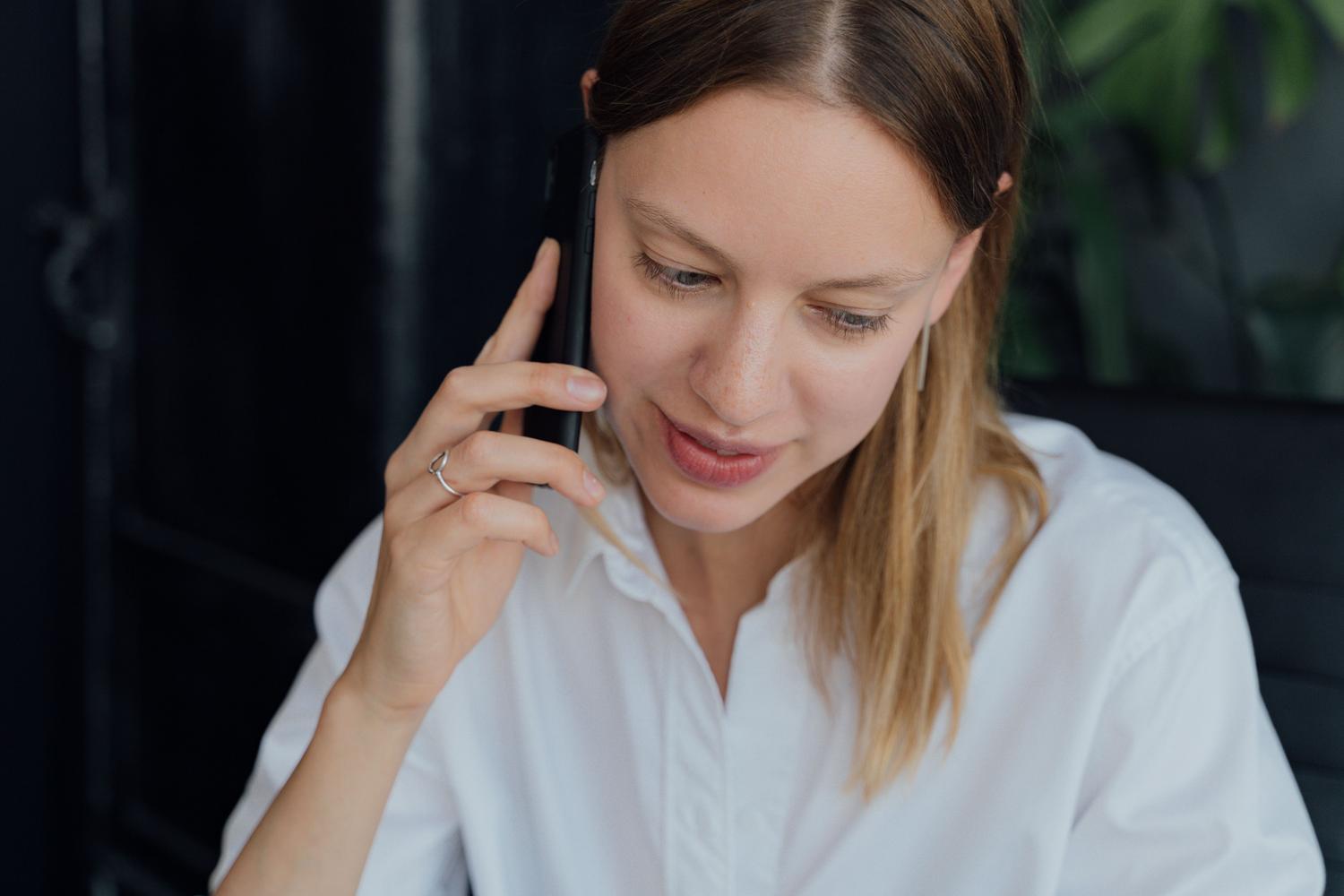 Mujer profesional realizando una llamada telefónica con su smartphone