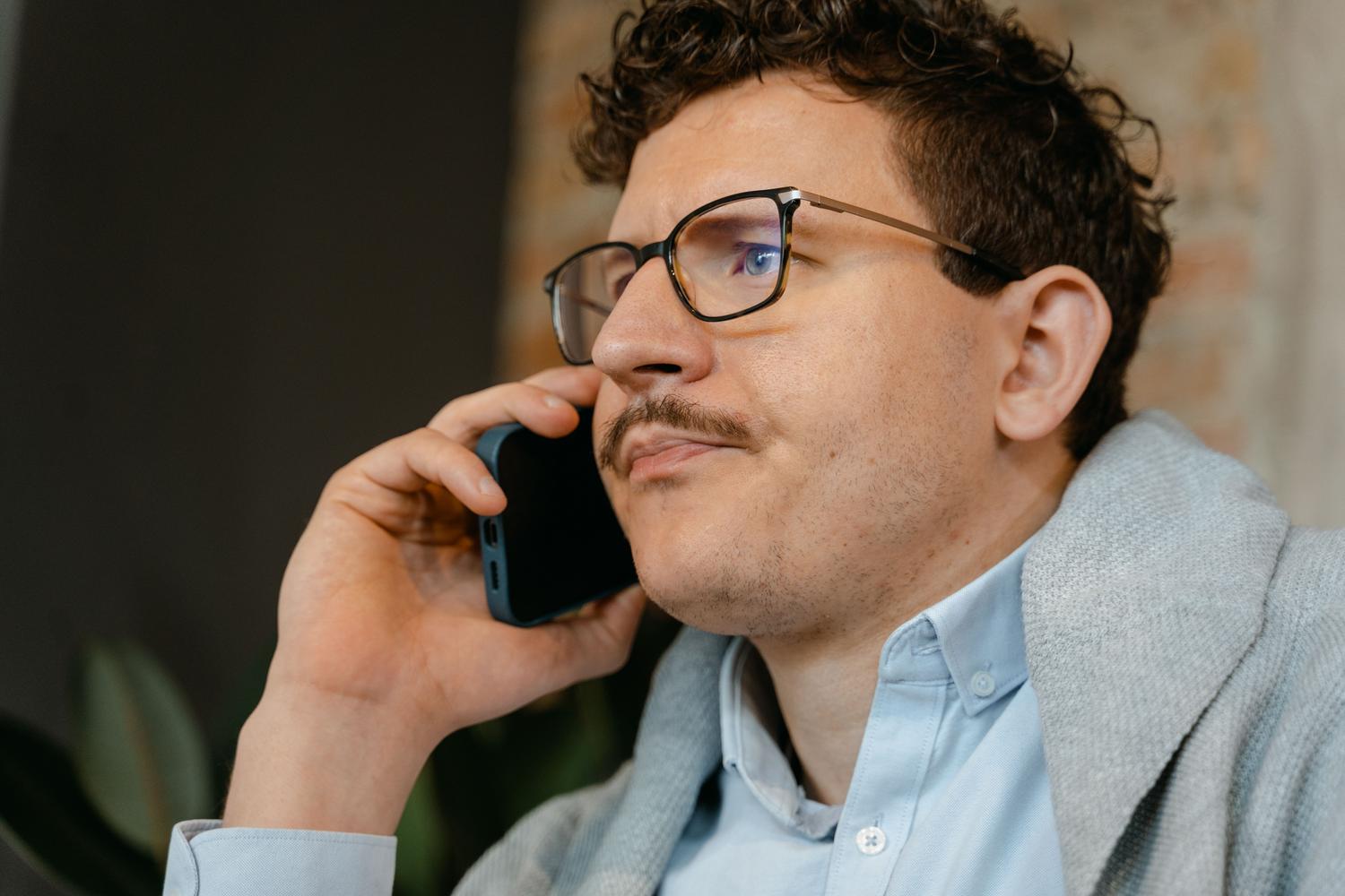 Hombre en entorno profesional hablando por teléfono móvil