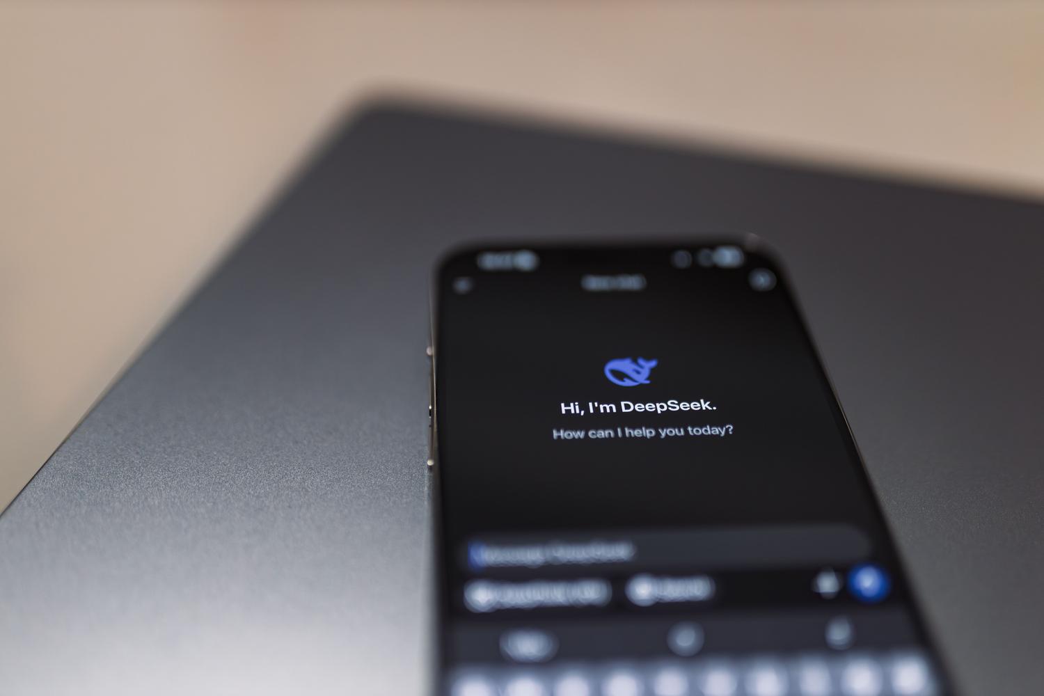 Smartphone mostrando um assistente de IA junto a um ordenador portátil, simbolizando a automatização e o comercio agentico.