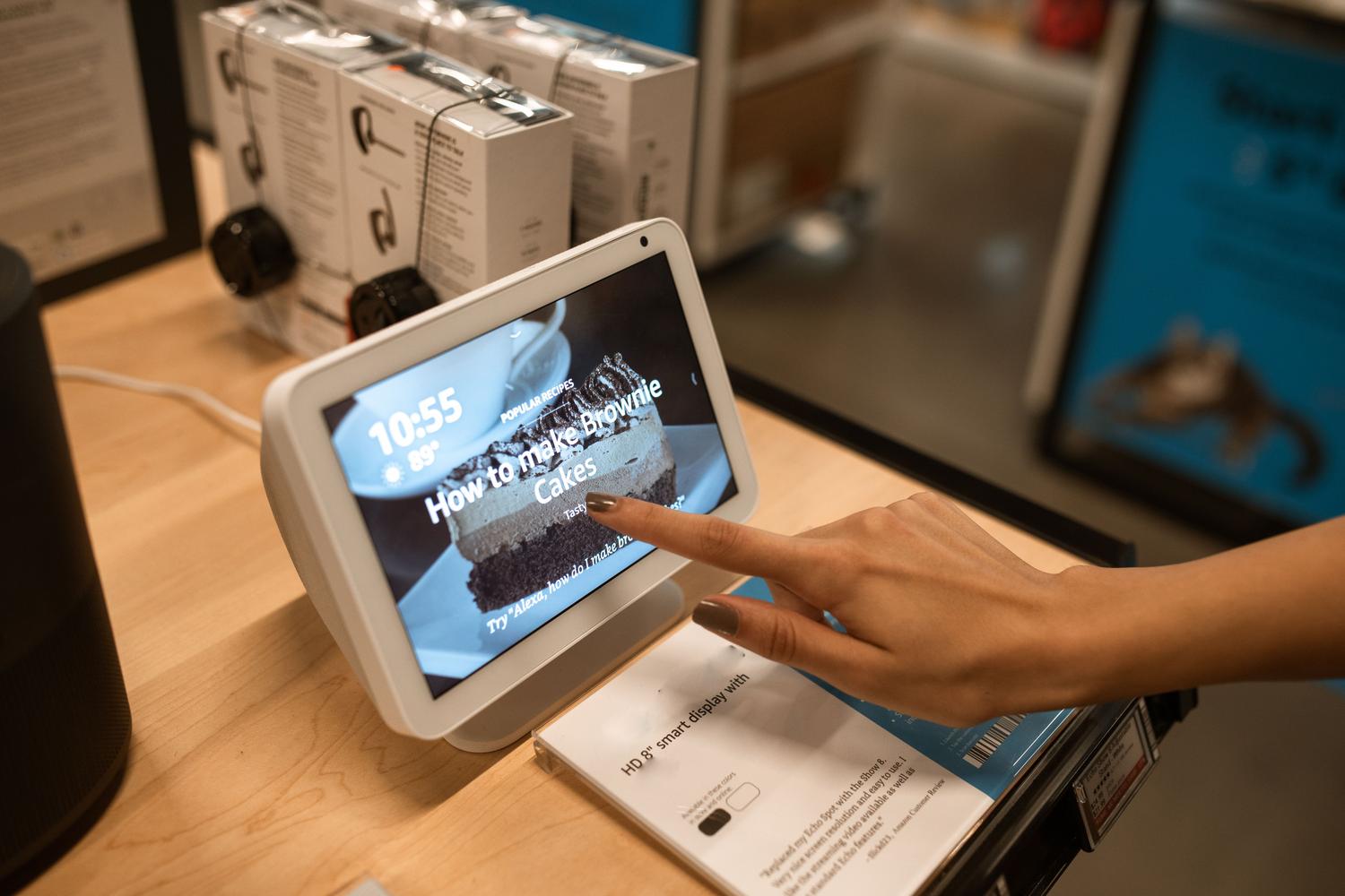 Mano interactuando con una pantalla inteligente en una tienda, ejemplificando el descubrimiento de productos mediante IA en el punto de venta.