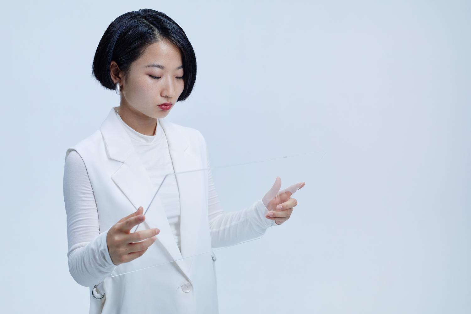 Mujer interactuando con una pantalla transparente futurista, representando la innovación tecnológica del mercado de RA.