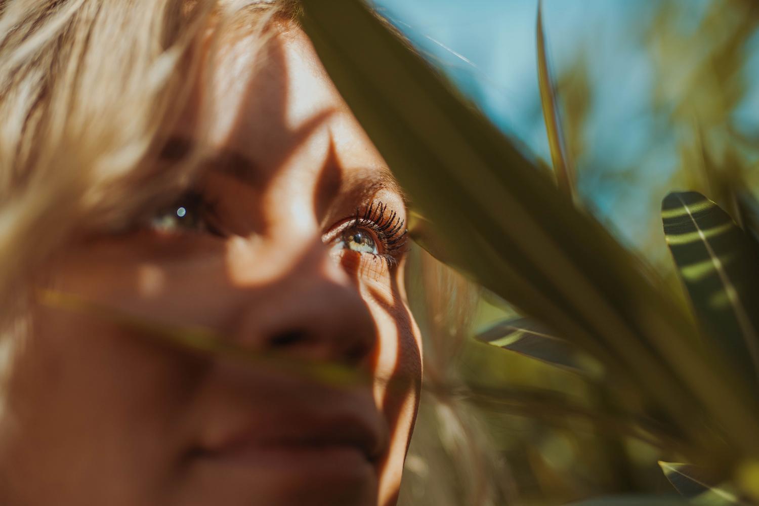 Mujer mirando la naturaleza em um momento de pausa, representando a regra 20-20-20 para reduzir a tensão ocular.