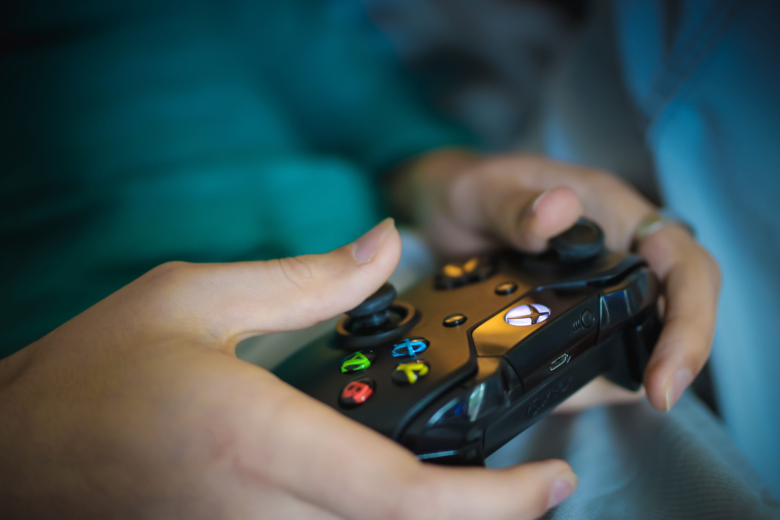 Primer plano de manos sujetando un mando de Xbox, representando la experiencia inmersiva del jugador final tras un proceso de localización exitoso.