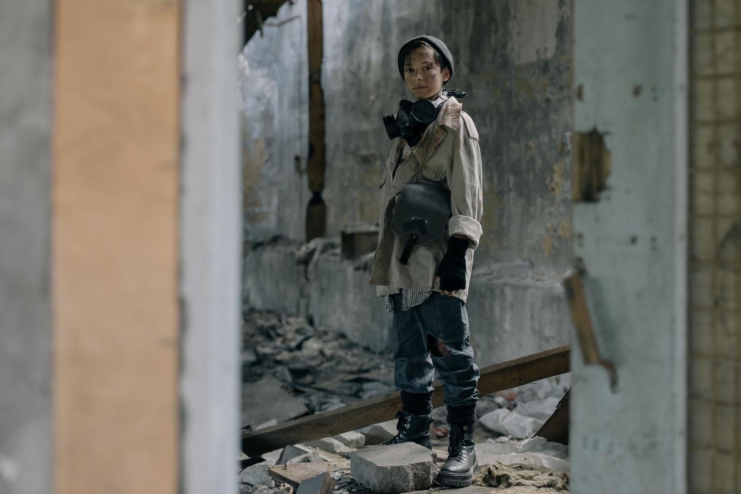Superviviente equipado com máscara de gas y ropa protectora en el interior de un edificio abandonado