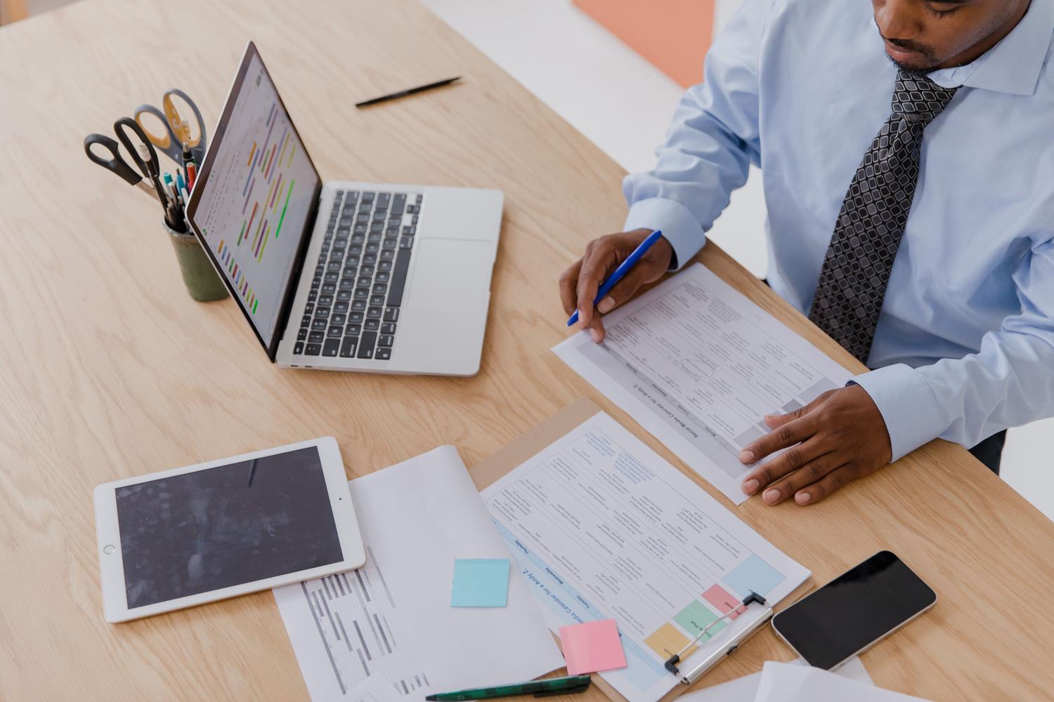 Entorno de oficina profesional con múltiples dispositivos y documentos, representando los riesgos de seguridad de datos en el ámbito corporativo.