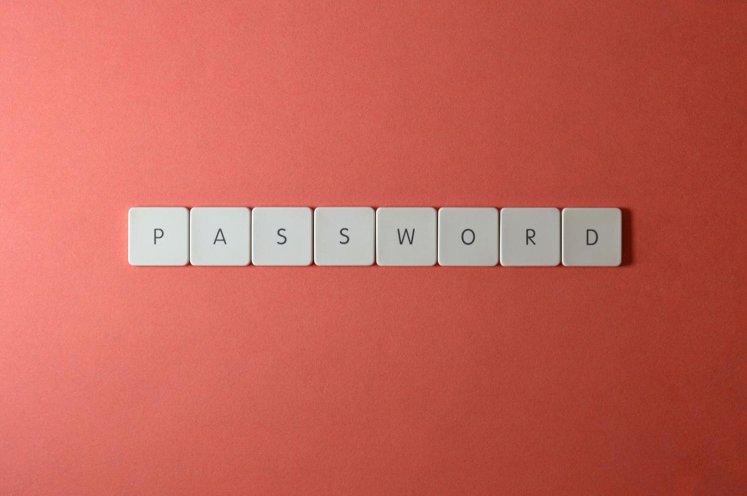 Teclas de teclado blancas deletreando la palabra 'PASSWORD' sobre un fondo coral, ilustración conceptual de contraseñas.