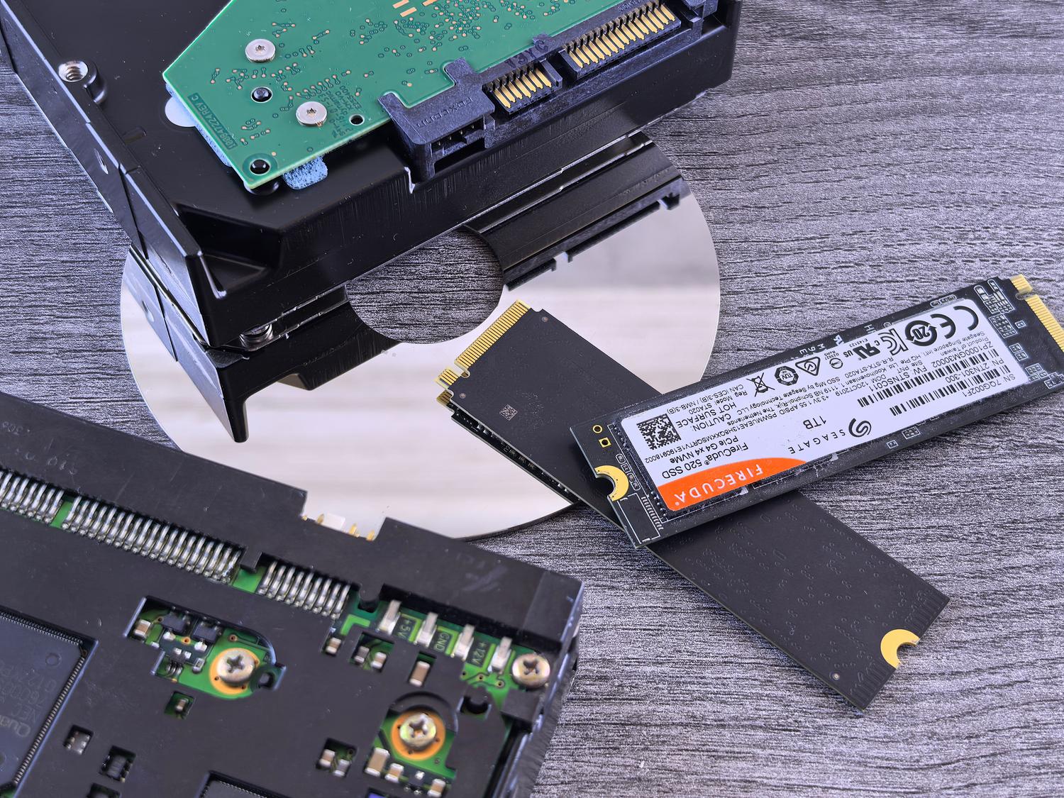 Comparativa visual de diferentes tecnologías de almacenamiento: SSD NVMe, disco duro HDD y CD