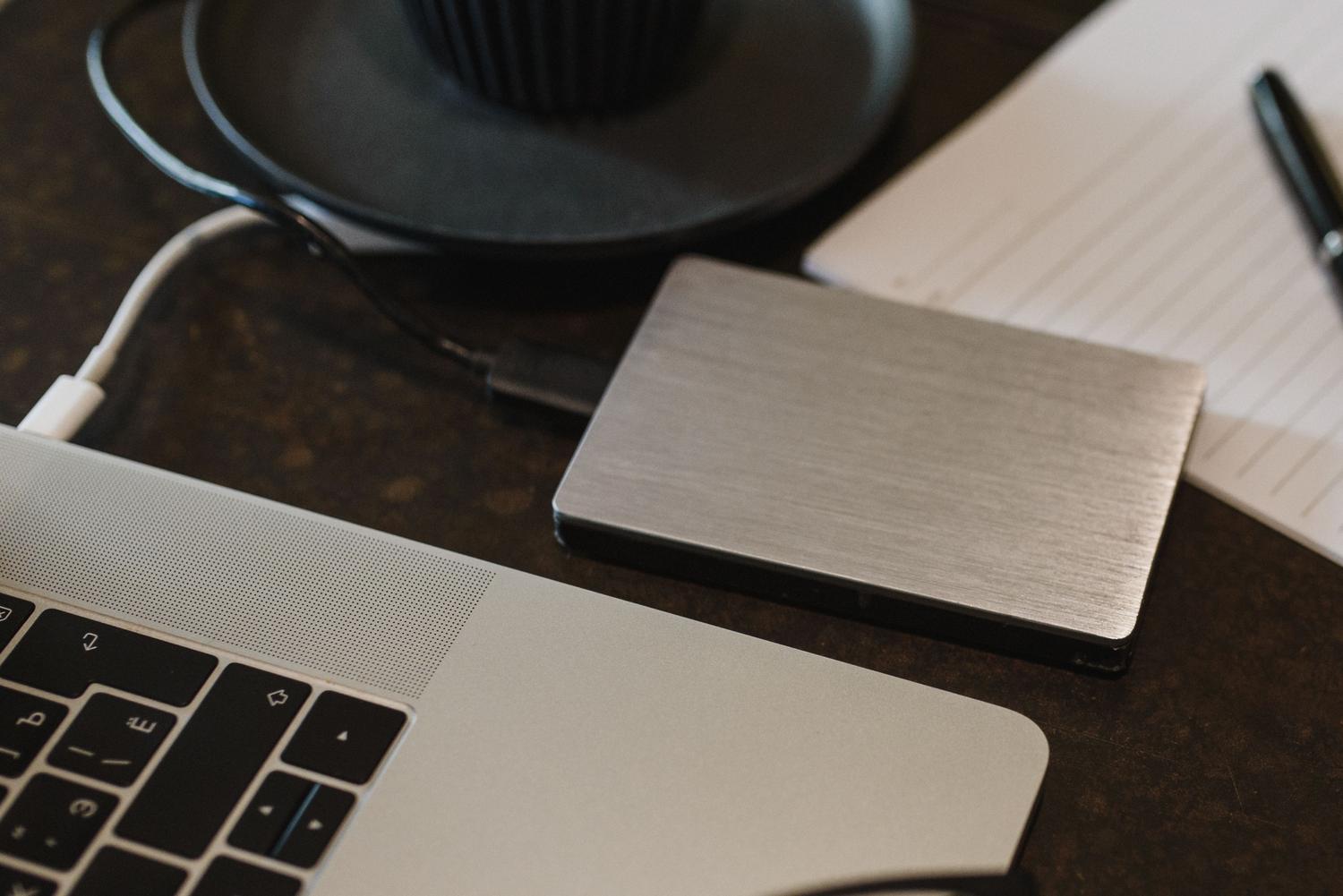 Disco duro externo conectado a un ordenador portátil mediante cable USB para realizar una copia de seguridad de datos