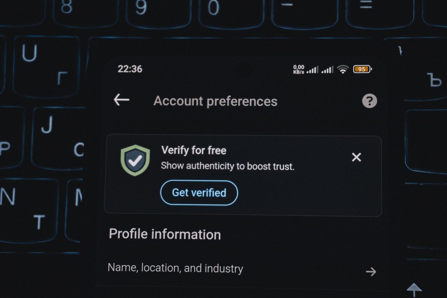 Primer plano de um smartphone mostrando uma alerta de verificação de conta, ideal para ilustrar a Verificação em Dos Passos (2SV).