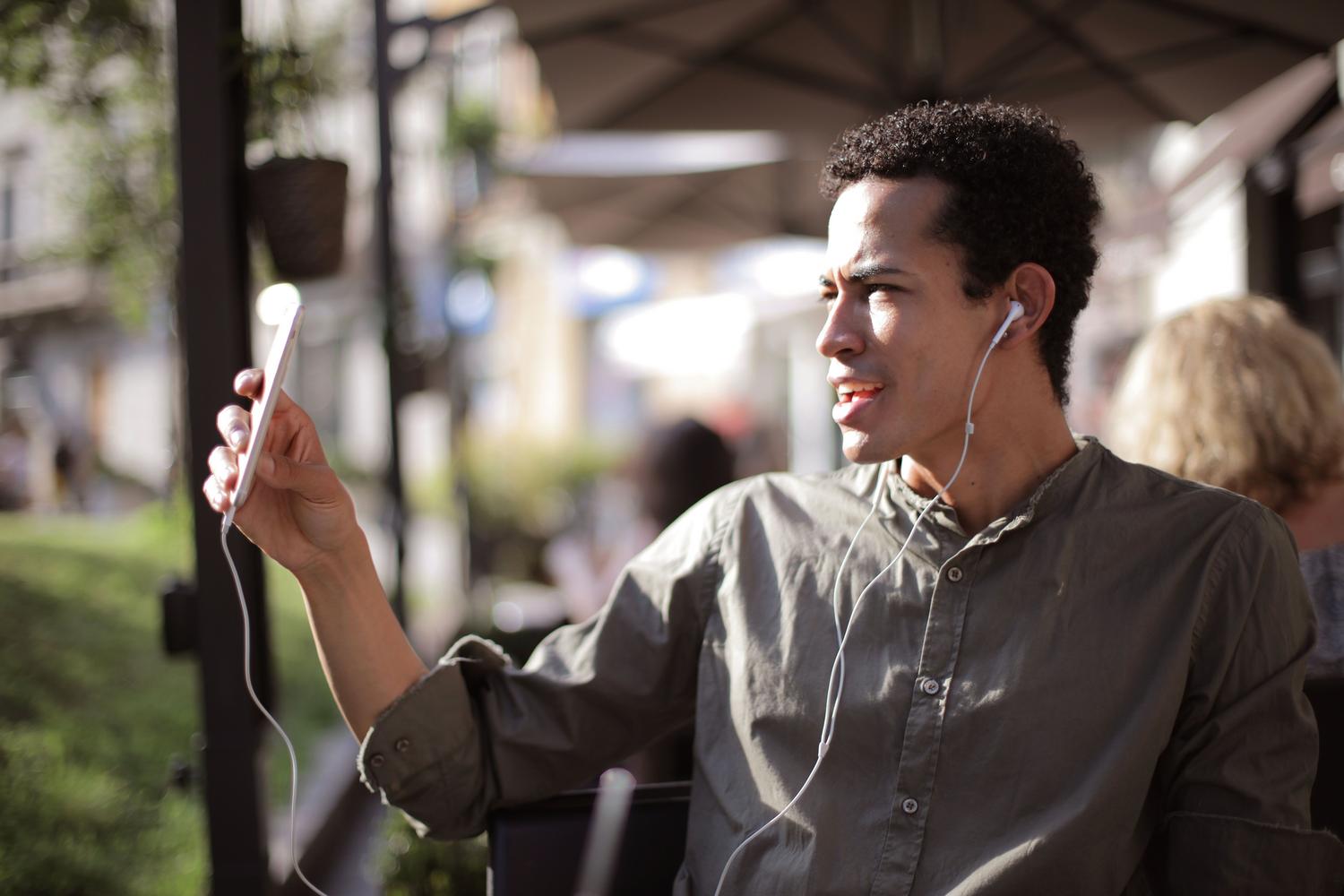 Hombre realizando una videollamada desde su smartphone en una terraza, representando la interacción dinámica de WhatsApp.