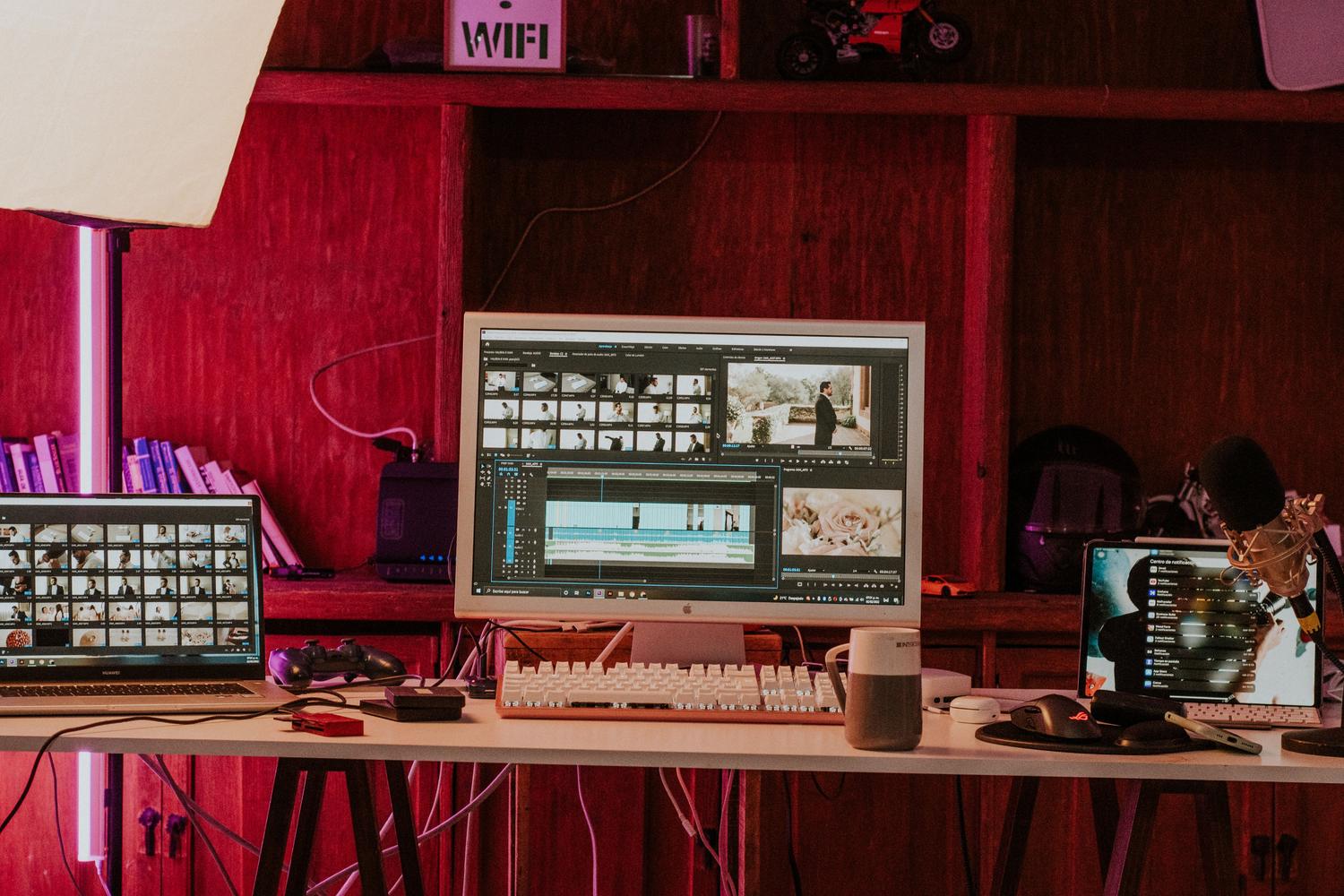 Espacio de trabajo de edición de vídeo profesional con monitores y equipos de estudio.
