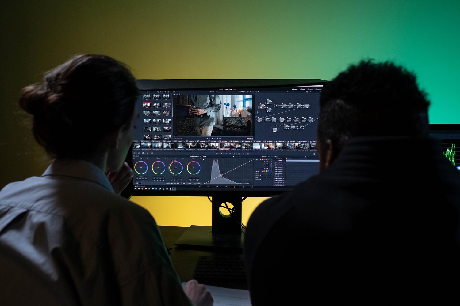 Equipo de profesionales colaborando en la edición de un vídeo en un entorno de oficina moderno.
