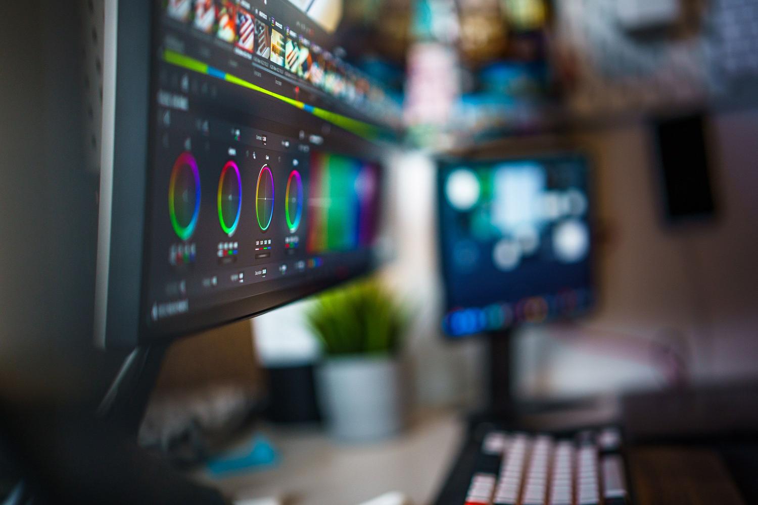 Estación de trabajo de edición de video profesional con monitores duales, representando el flujo de trabajo de postproducción avanzada.