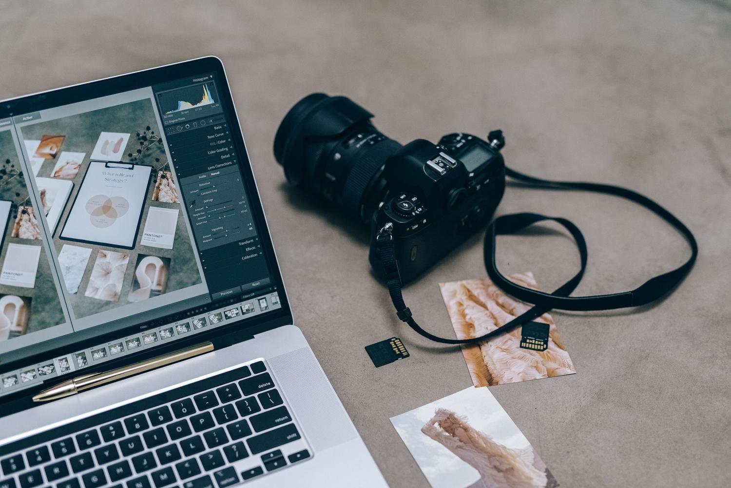 Cámara DSLR y ordenador portátil con software de edición, mostrando la integración entre la captura de imagen y el revelado digital.