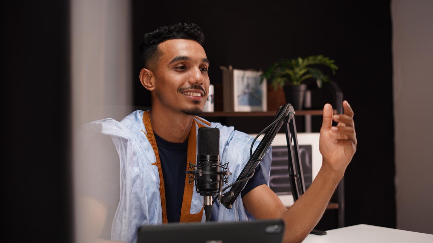 Persona grabando un podcast en un estudio casero utilizando software de edición de audio como Audacity