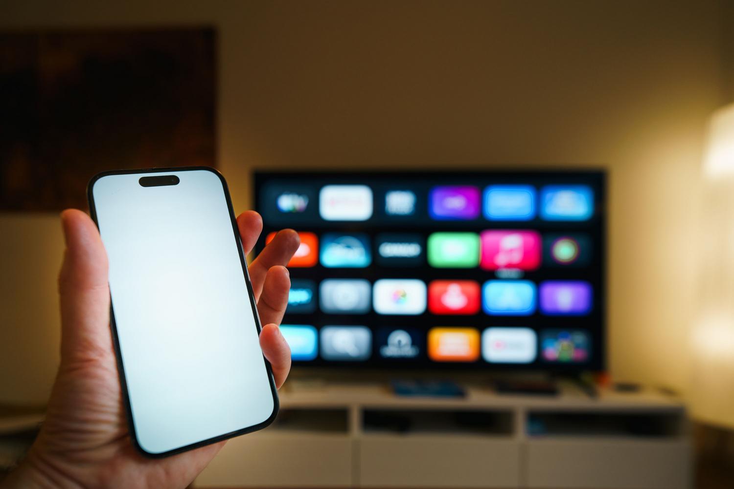 Interacción entre un smartphone y una Smart TV, reflejando la conectividad del ecosistema de dispositivos.