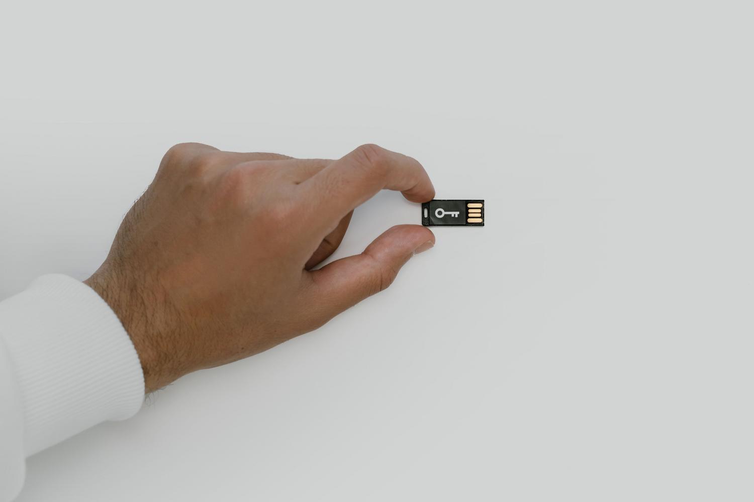 Primer plano de una memoria USB con un símbolo de llave, representando el control y la seguridad de la propiedad digital.