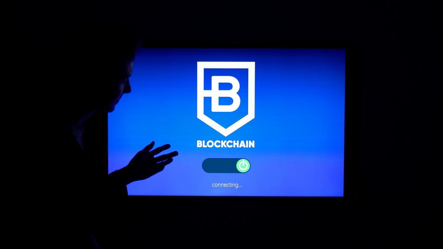 Silueta de una persona interactuando con una pantalla de tecnología blockchain, ilustrando la transición hacia la Web 3.0 y la descentralización.