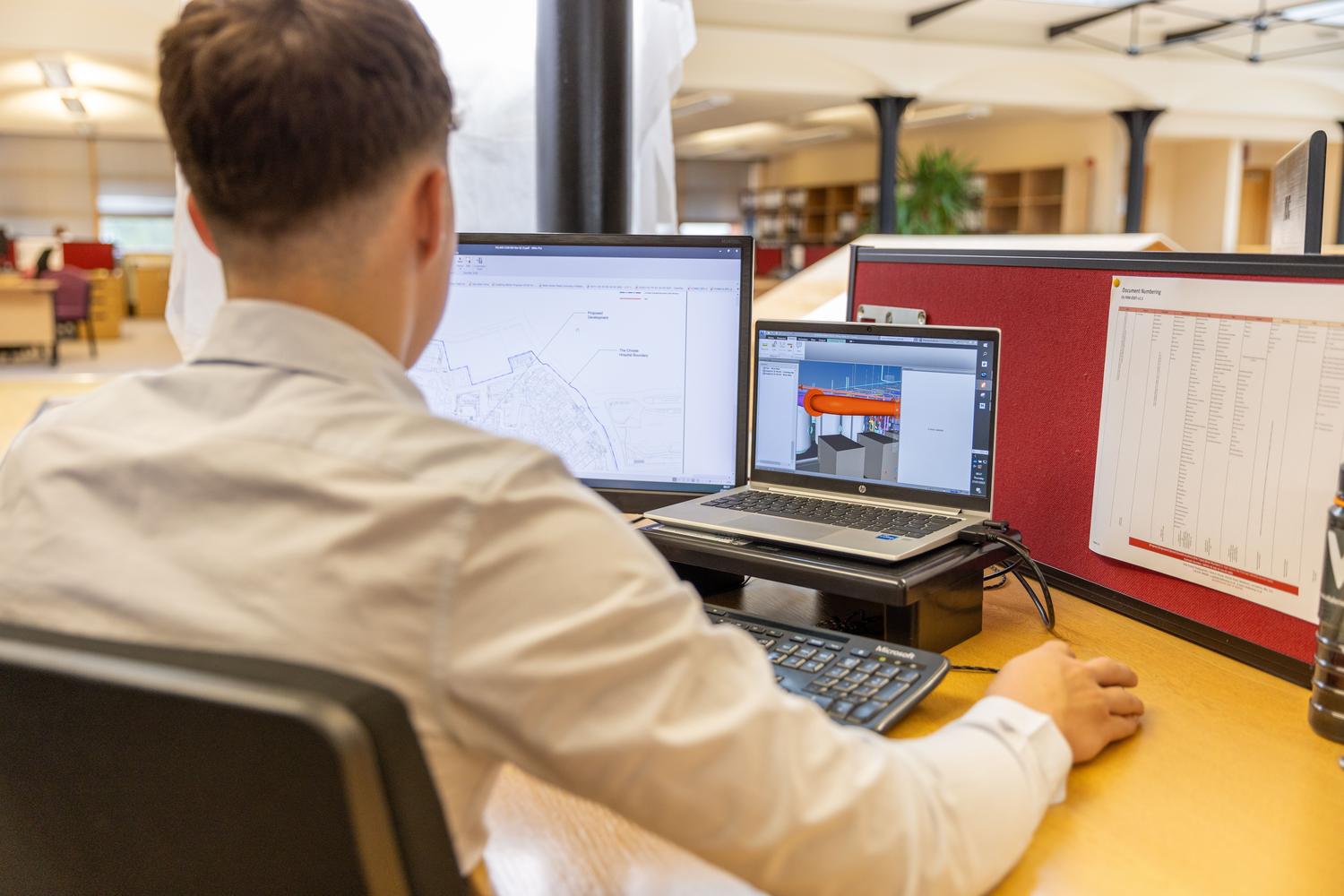 Ingeniero trabajando em um diseño CAD utilizando una estación de trabajo con monitores duales.