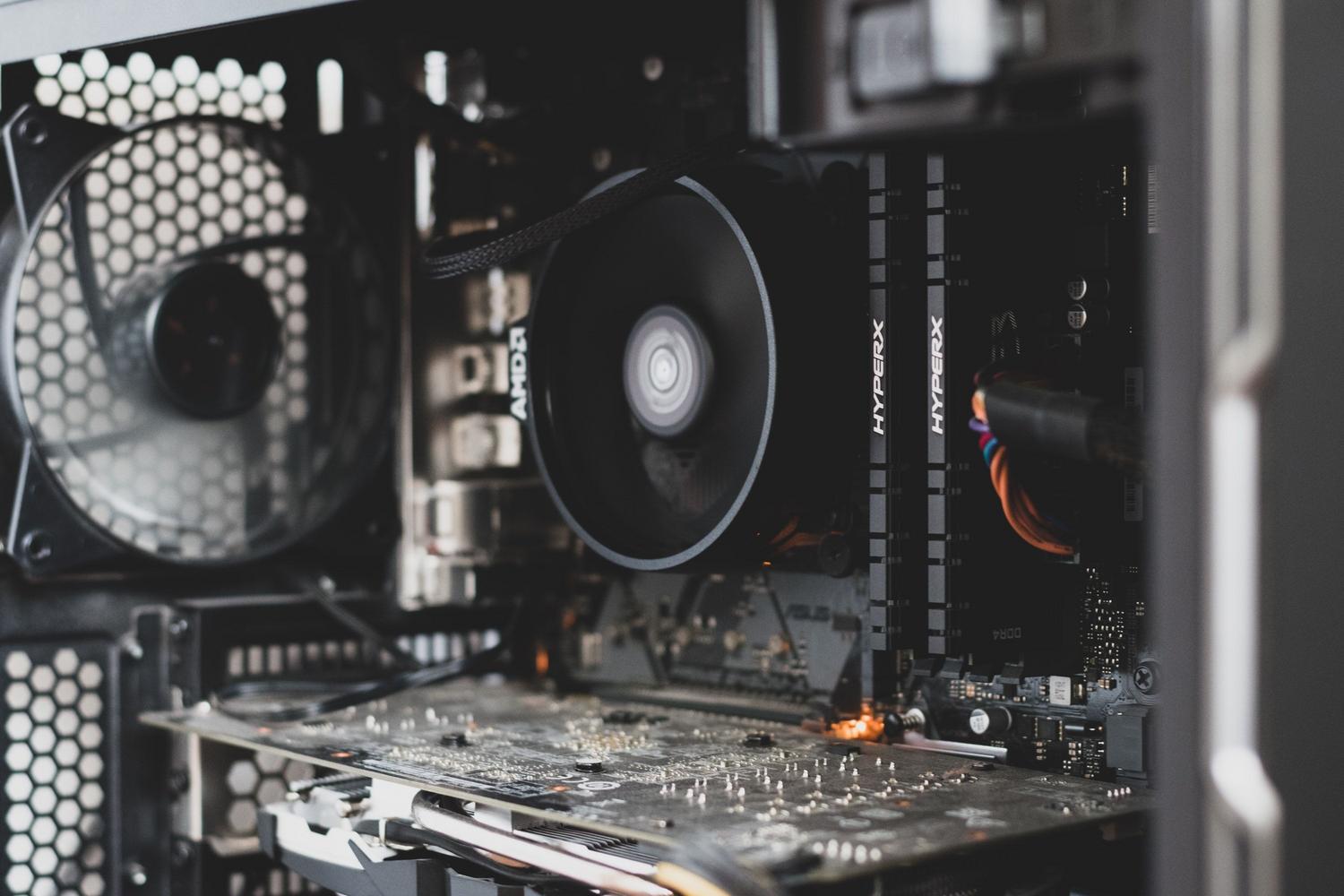 Vista detallada de los componentes internos de un ordenador, mostrando la placa base y el sistema de refrigeración, ideal para ilustrar los requisitos técnicos de hardware.