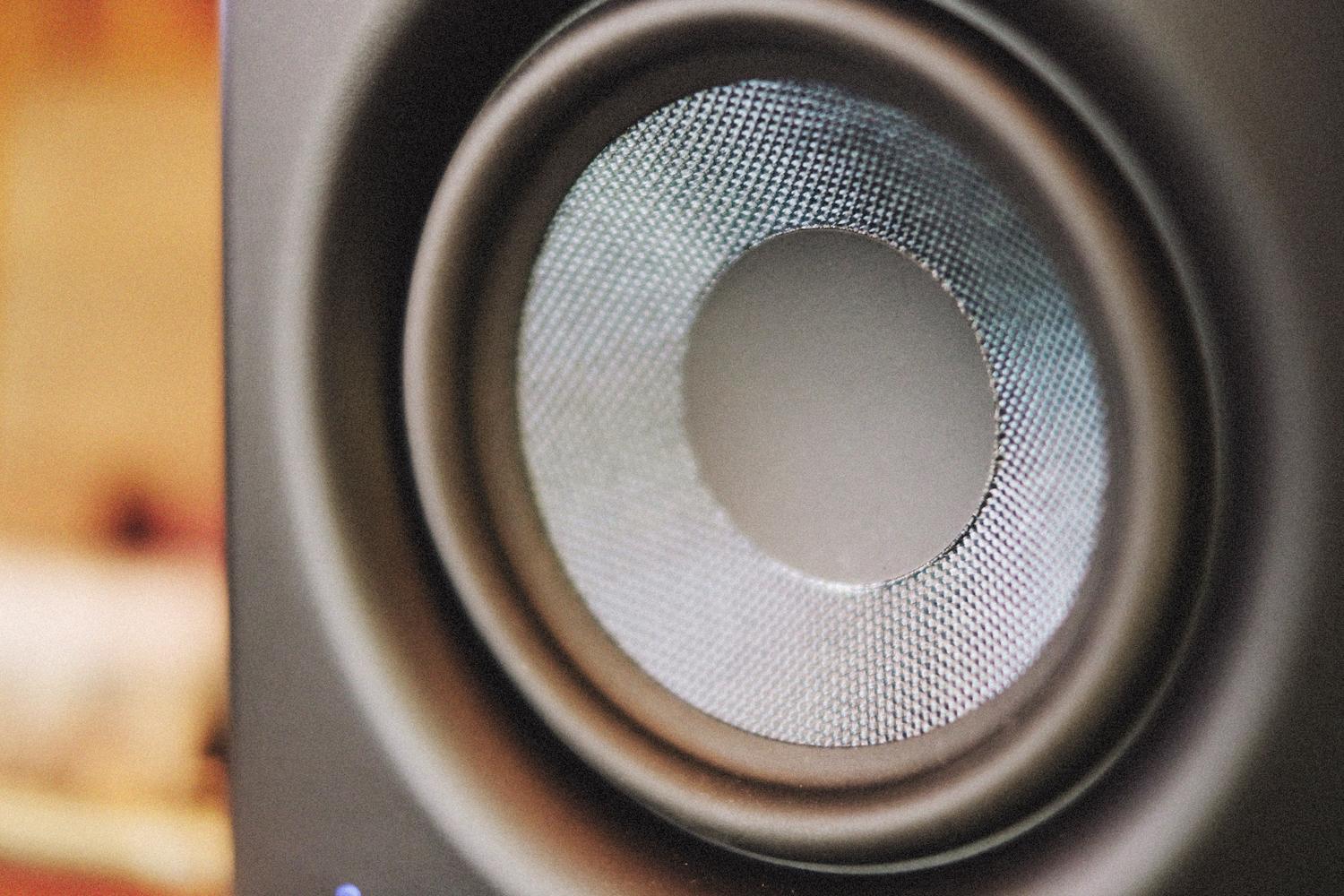Primer plano detallado del cono de un altavoz moderno, ilustrando la tecnologia de transductores y hardware de audio.