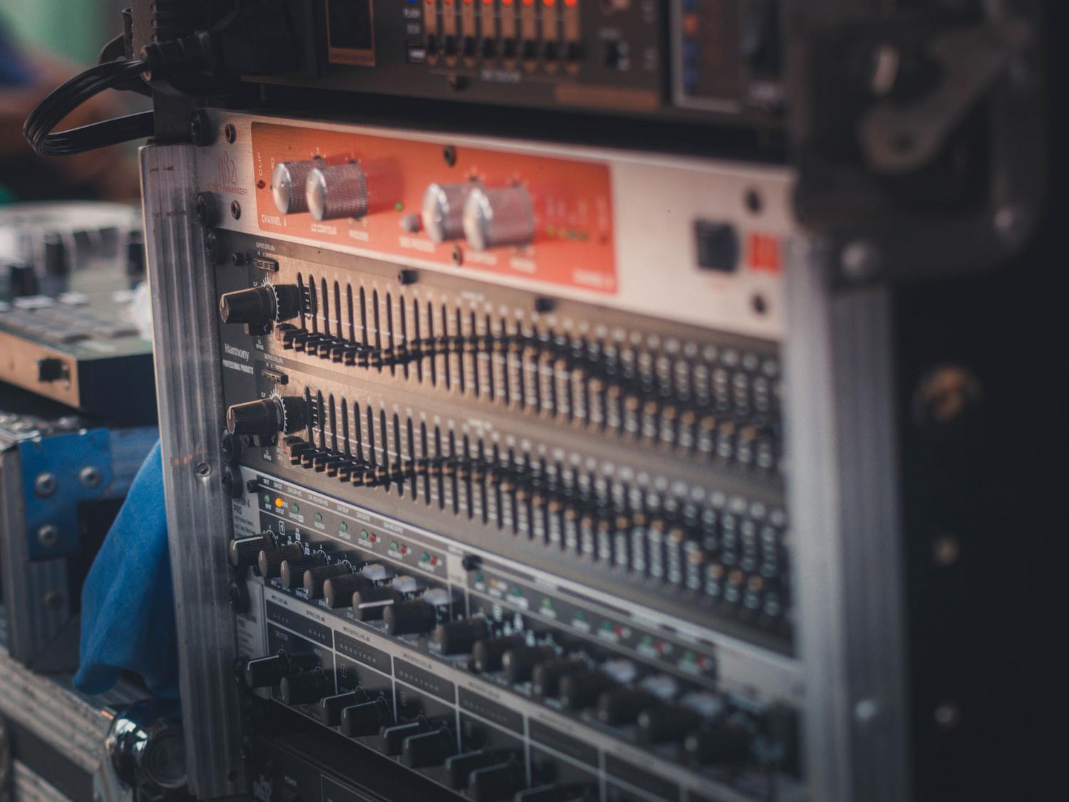 Rack de equipo de audio profesional con ecualizador gráfico, representando el procesamiento externo de señales para optimización de graves.