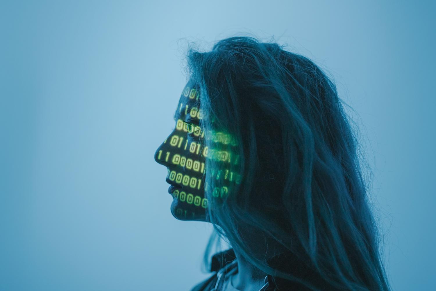Silueta de una persona con código binario proyectado en su rostro, representando la identidad digital y la inteligencia artificial.