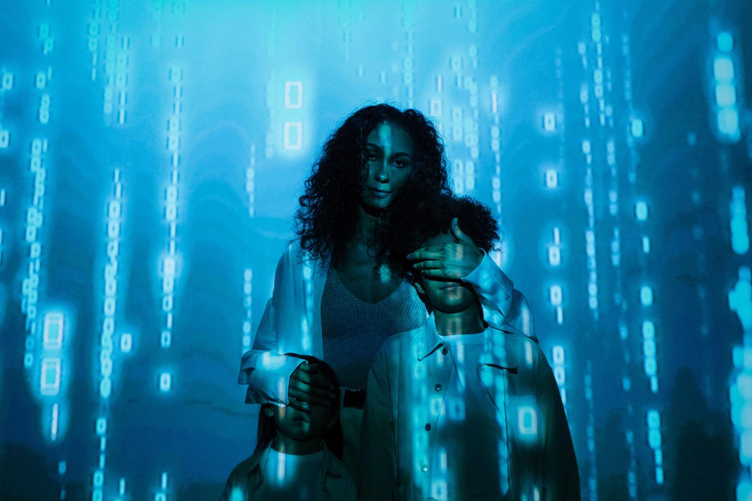 Familia protegida bajo una lluvia de datos binarios en tonos azules, simbolizando la privacidad de los datos y la protección de la identidad digital.