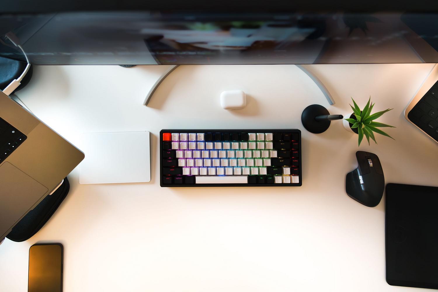 Espacio de trabajo minimalista en casa con un teclado mecánico compacto y accesorios de productividad.