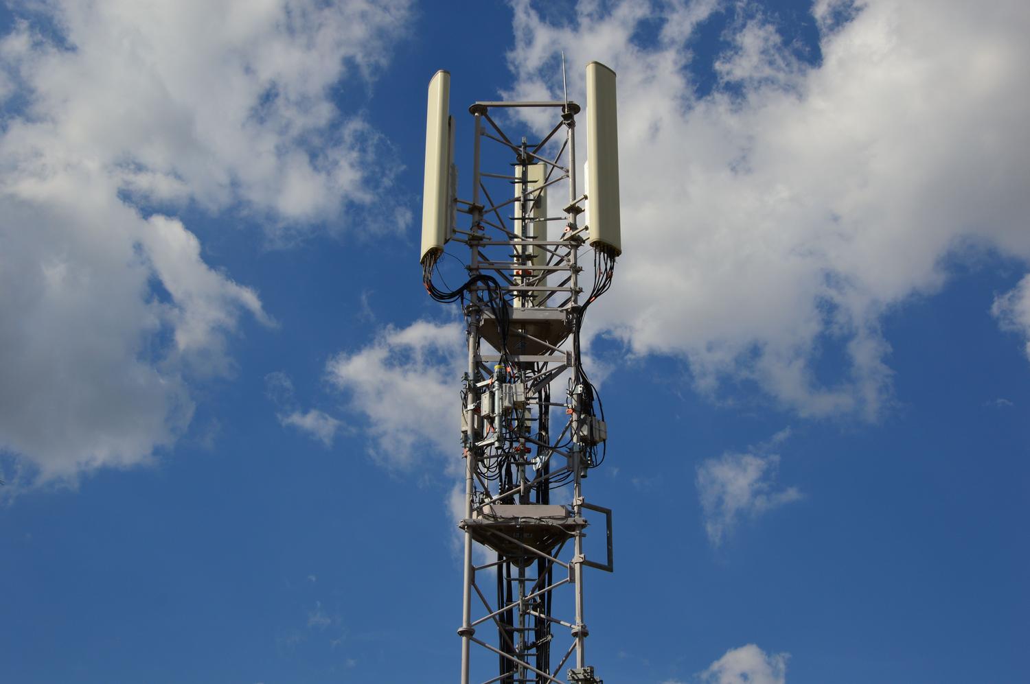 Torre de comunicaciones móvil con antenas contra un cielo azul, representando la infraestructura de red móvil.