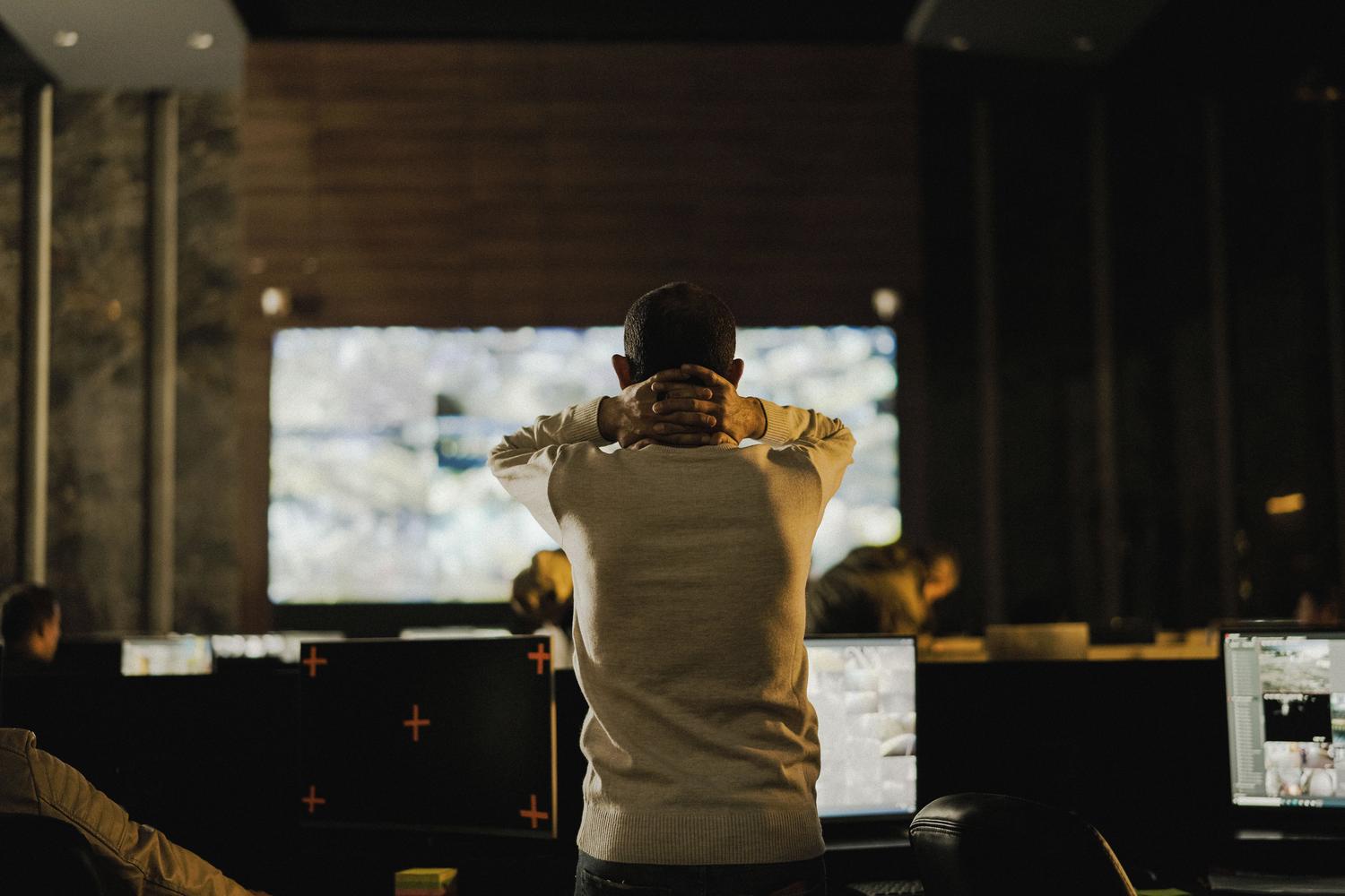 Profissional de IT supervisando sistemas em uma sala de control, simbolizando a governança da IA e a prevenção da 'Shadow AI'.