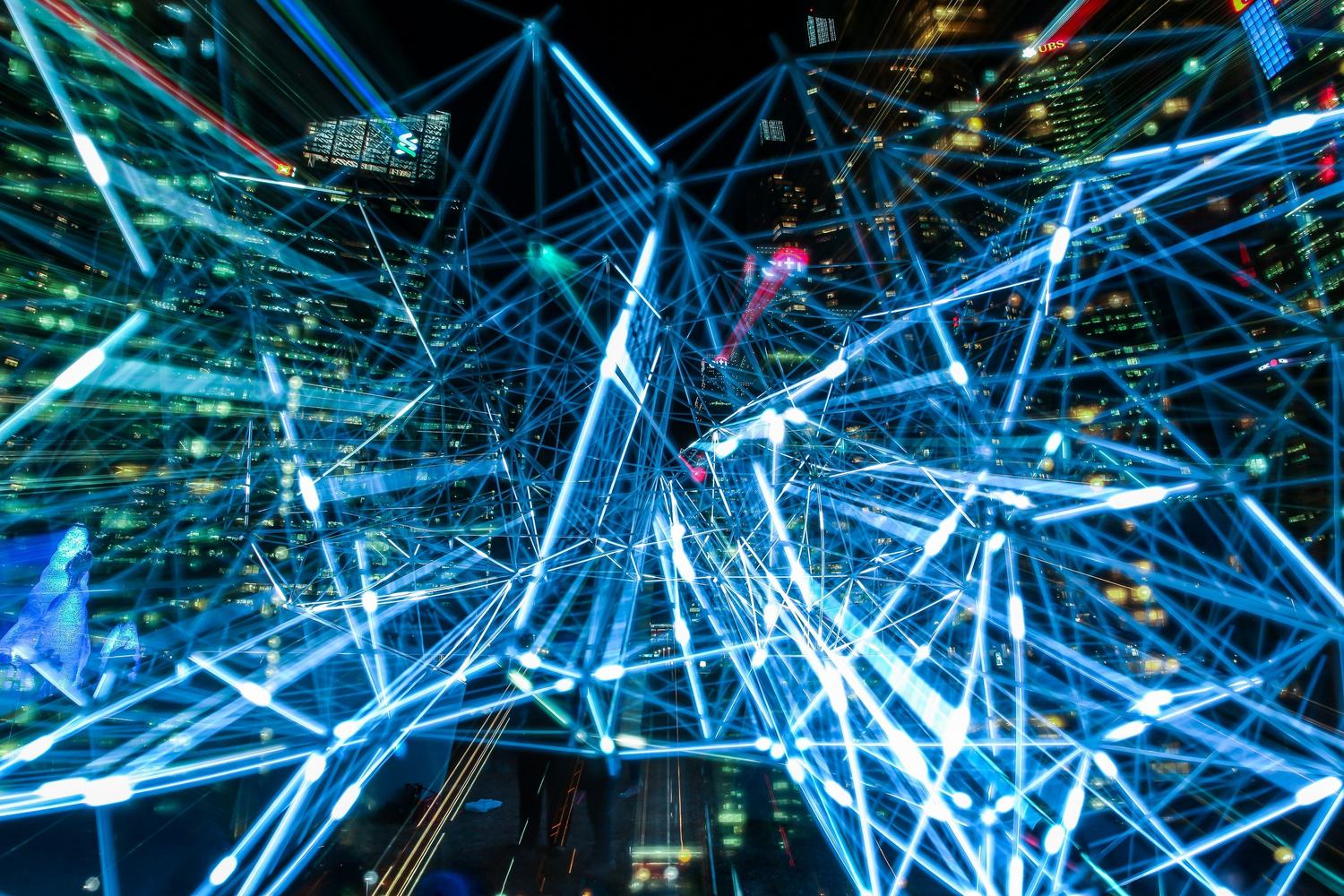 Imagen abstracta de trazos de luz urbanos que representan la interconectividad digital y las redes de ciudades inteligentes (Smart Cities).