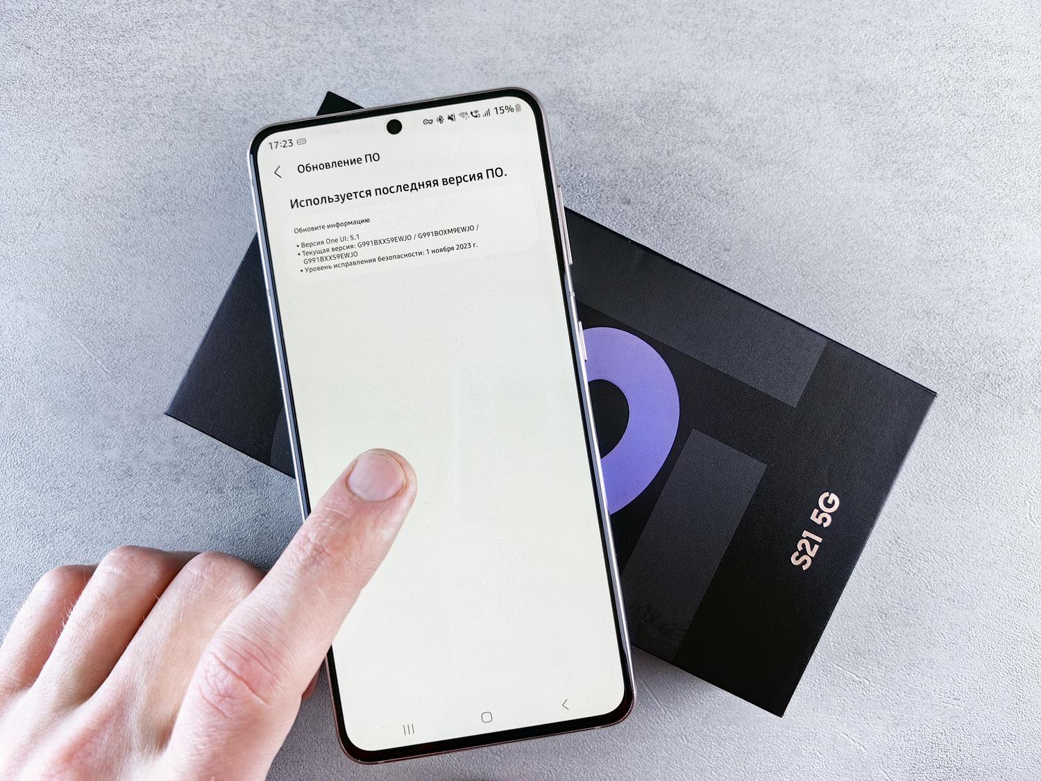 Primer plano de un dedo interactuando con la pantalla de actualización de software de un smartphone, representando el proceso de instalación de nuevas versiones.