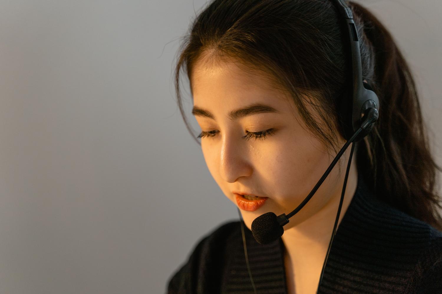 Agente de soporte al cliente concentrada utilizando auriculares, ilustrando la agilidad y calidad en la resolución de incidencias.