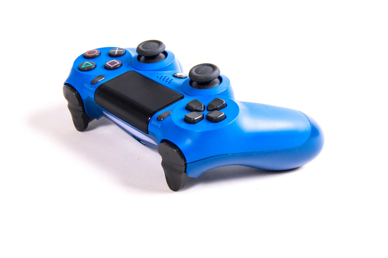 Mando inalámbrico DualShock 4 azul sobre fondo blanco, resaltando el diseño y los componentes del dispositivo.