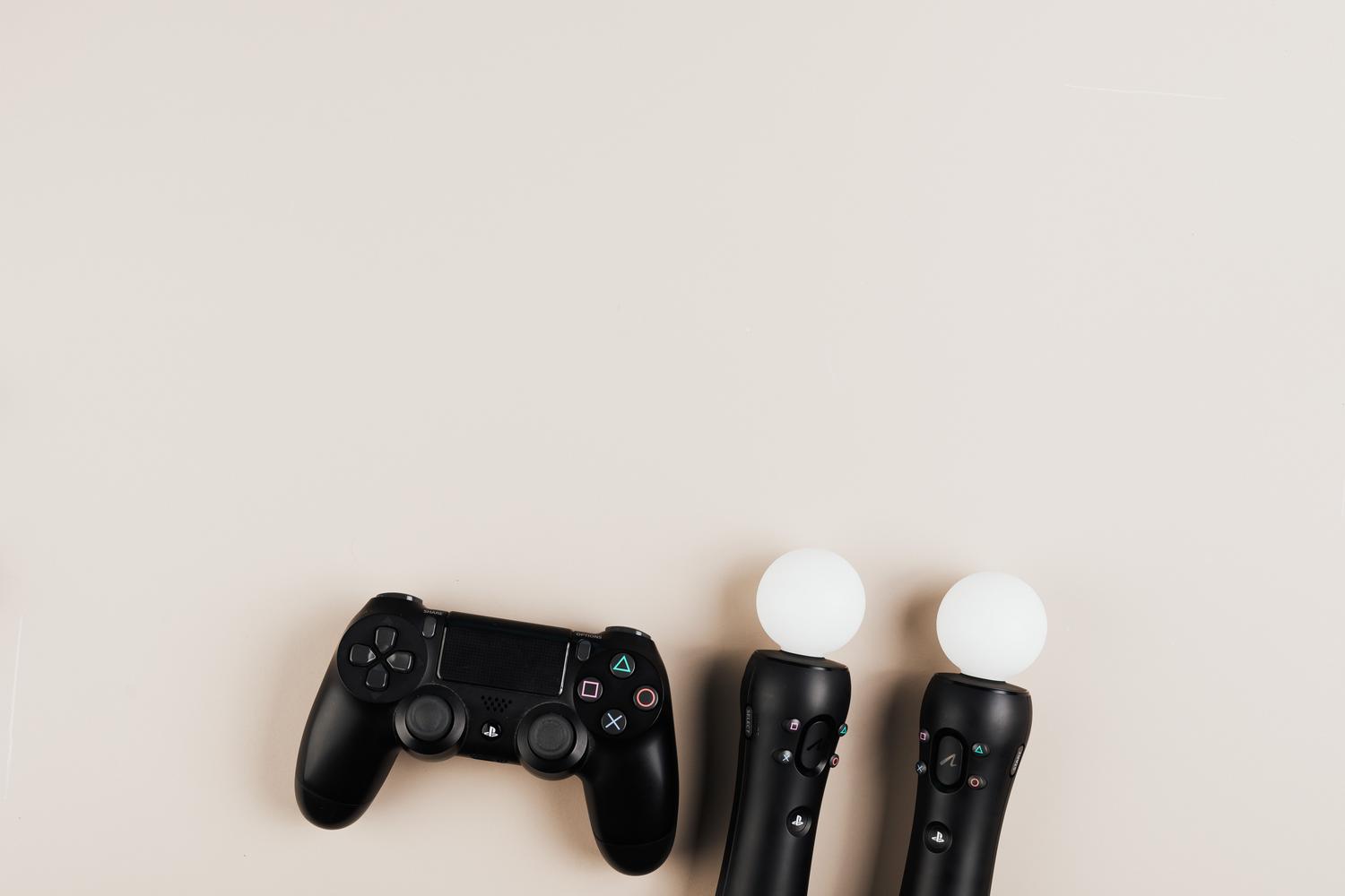 Vista cenital de mandos de PlayStation negros sobre un fondo neutro, proporcionando un aspecto técnico y profesional.