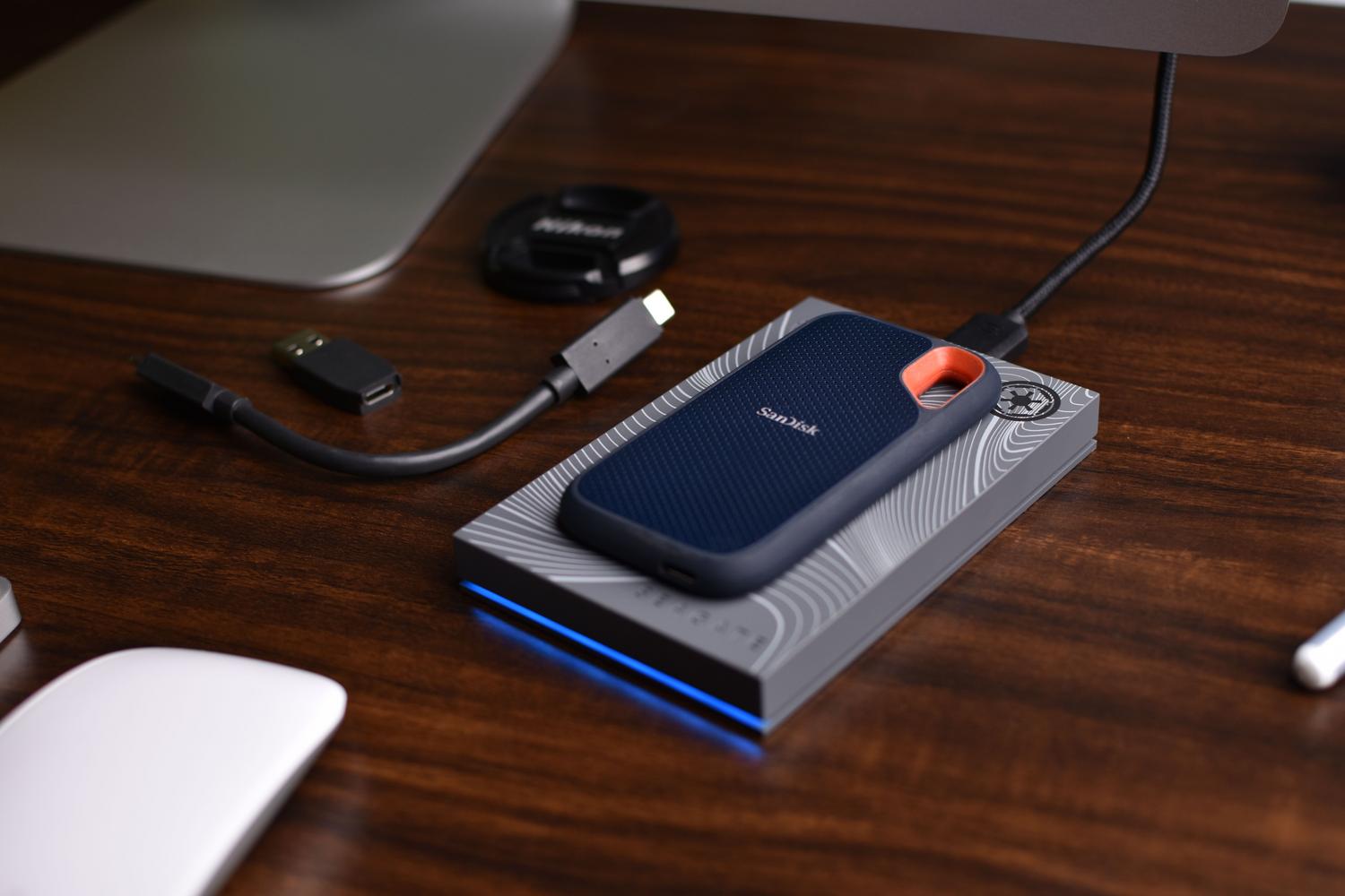Primer plano de un SSD portátil SanDisk sobre un escritorio tecnológico, destacando la portabilidad y velocidad.