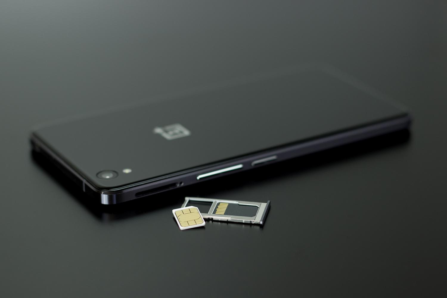 Detalle de una tarjeta SIM y una tarjeta de memoria junto a un smartphone, representando la conectividad móvil