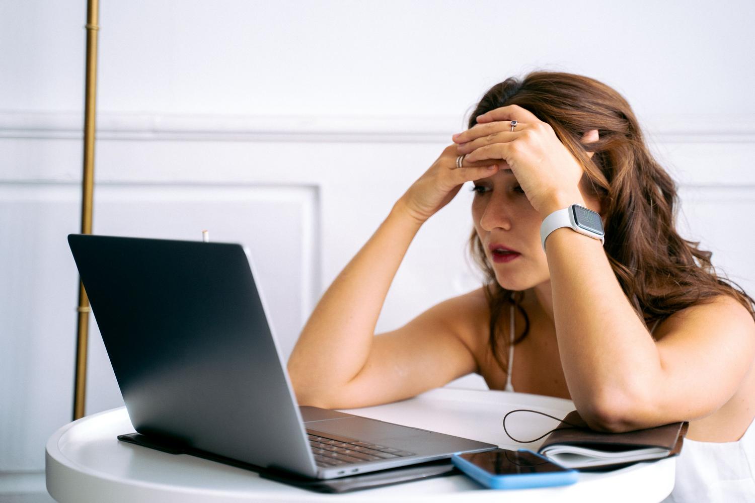 Mujer sintiéndose abrumada mientras configura dispositivos, representando los errores comunes de software y configuración en los amplificadores WiFi.
