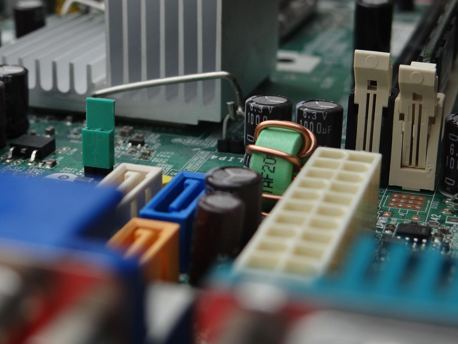 Vista detallada de conectores de alimentación y componentes electrónicos en uma placa base.