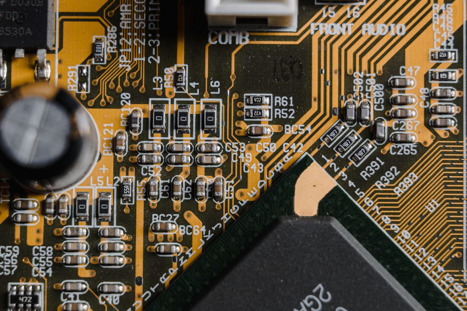 Fotografía macro de un chip integrado y trazas de cobre en uma placa base.