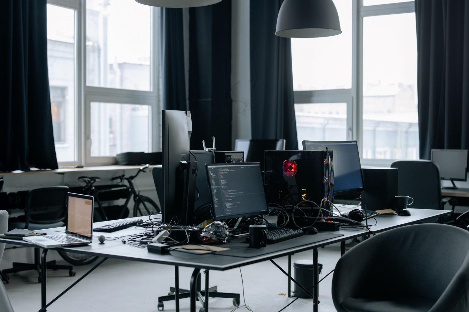 Espacio de trabajo tecnológico moderno con pantallas de código, representando el entorno de desarrollo e implementación de la IA corporativa.