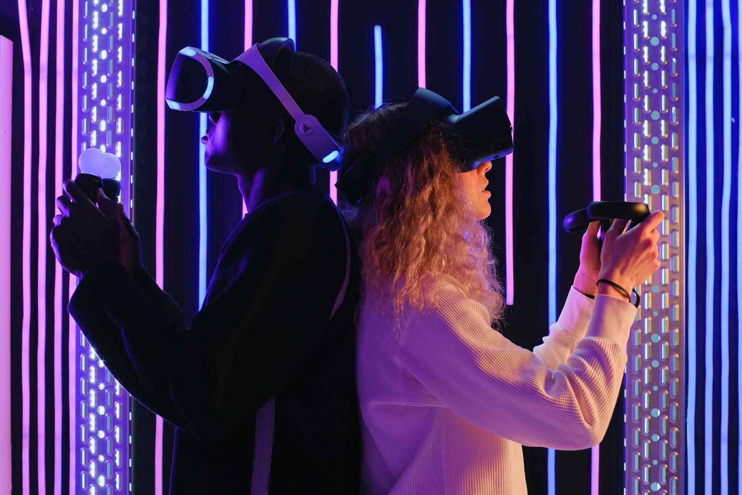 Dos personas compartiendo una experiencia inmersiva de juego en el metaverso con cascos de realidad virtual, destacando la socialización digital.