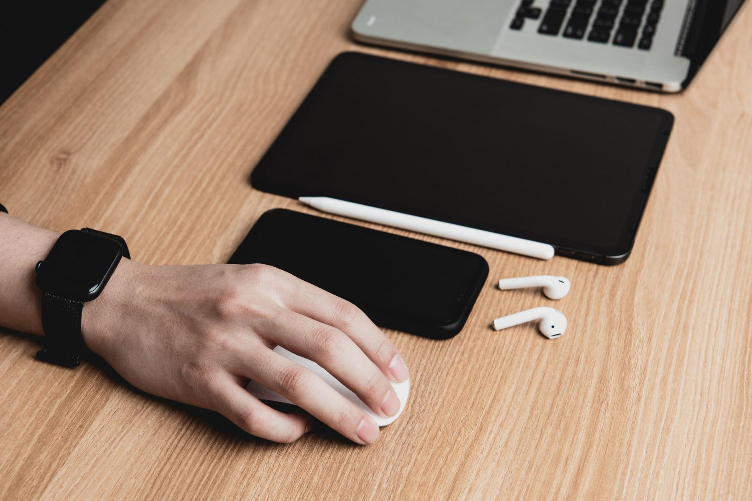 Interacción con diversos dispositivos digitales sobre un escritorio, simbolizando la accesibilidad de favoritos y contraseñas en la nube.